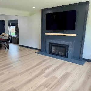 Light laminate flooring in a living room with a modern fireplace